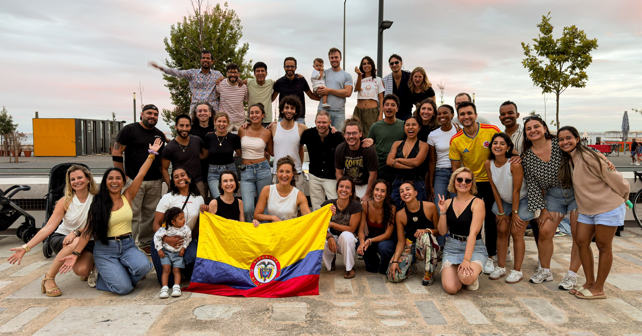 Sofi e a sua comunidade de dança reunidas à volta de uma bandeira colombiana em Lisboa